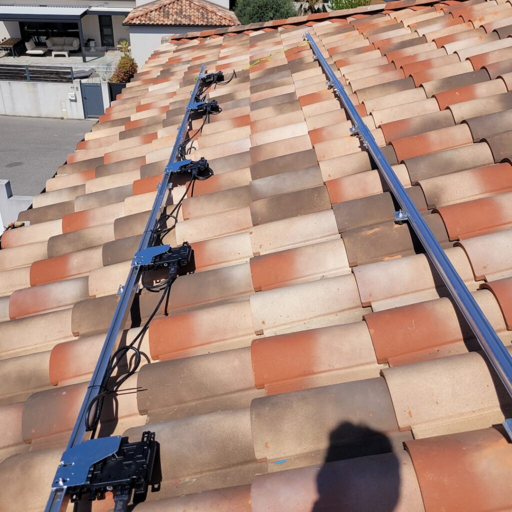 Fixation de panneaux solaires installée sur un toit de tuiles pour réaliser des économies d'énergie dans l'hérault.