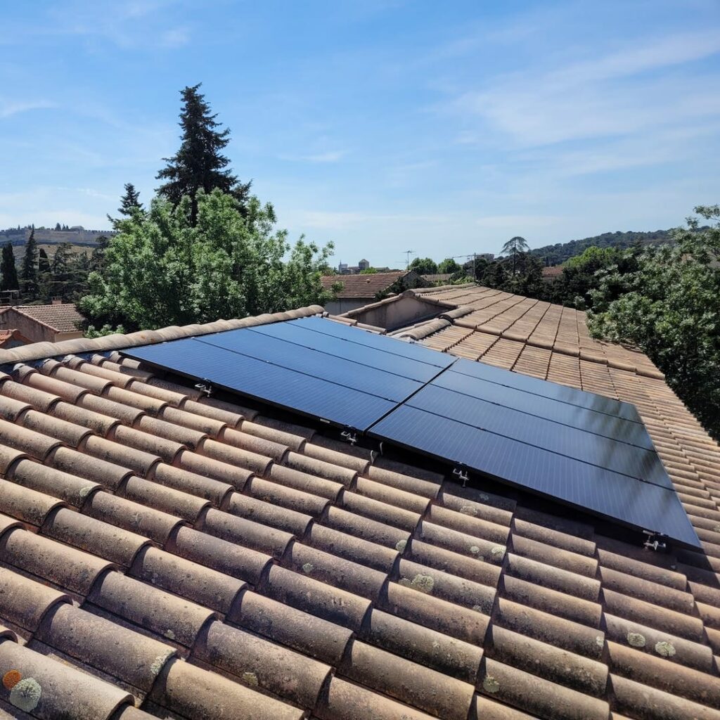 Panneaux solaires posés sur un toit de tuiles ocres pour réaliser des économies d'énergie